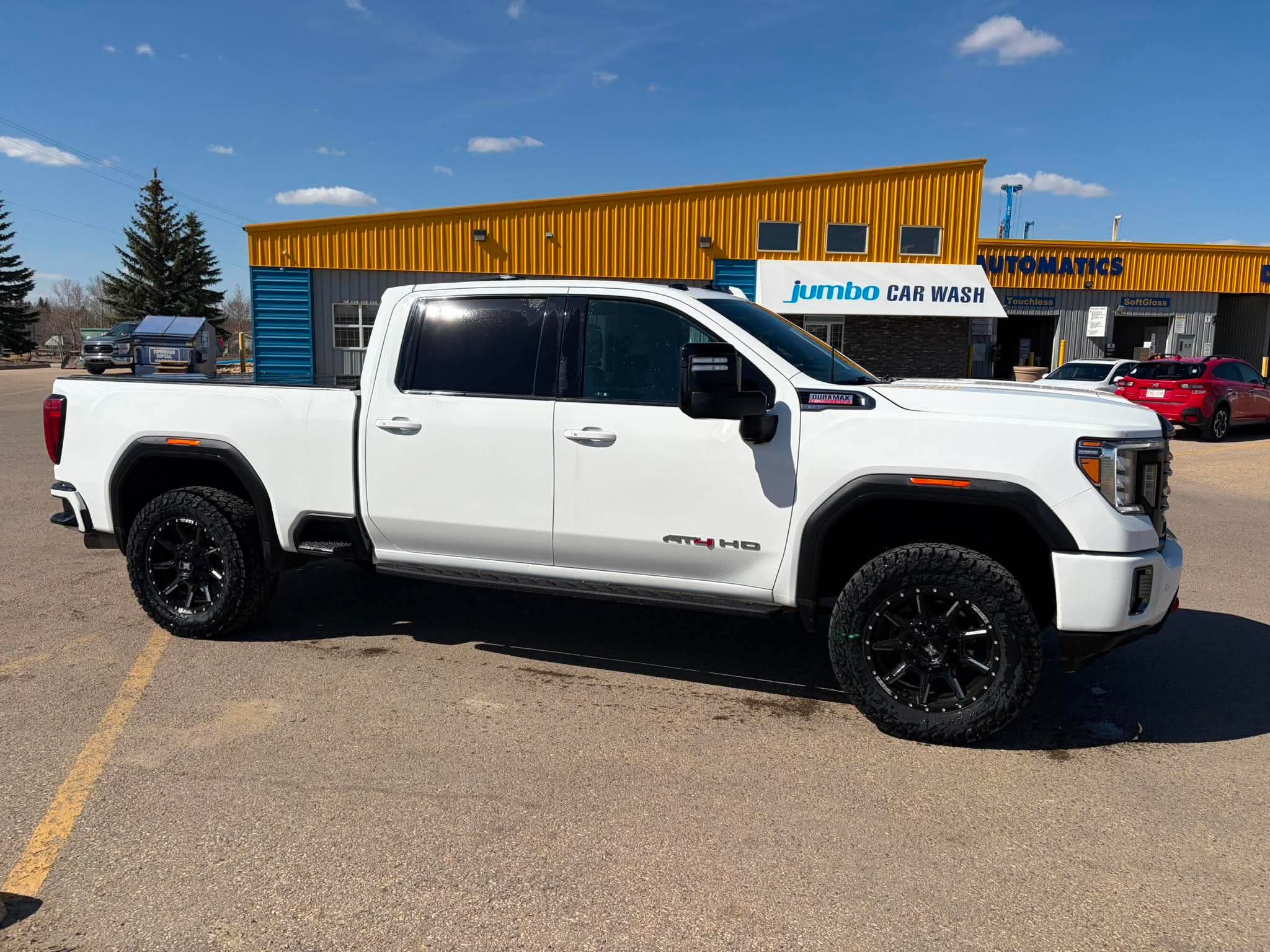 White GMC Sierra AT4 HD on black off-road wheels
