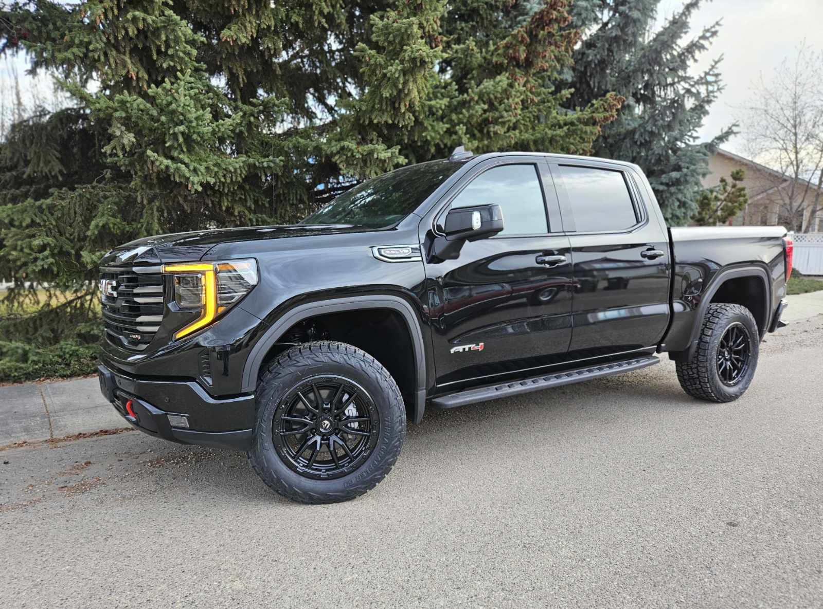 Black GMC Sierra AT4 on black off-road wheels