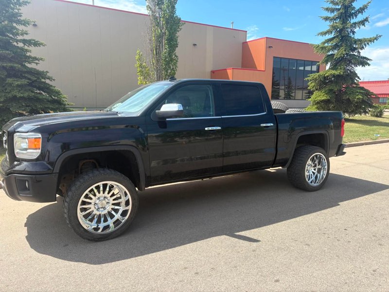 Black GMC Sierra lifted on chrome forged wheels