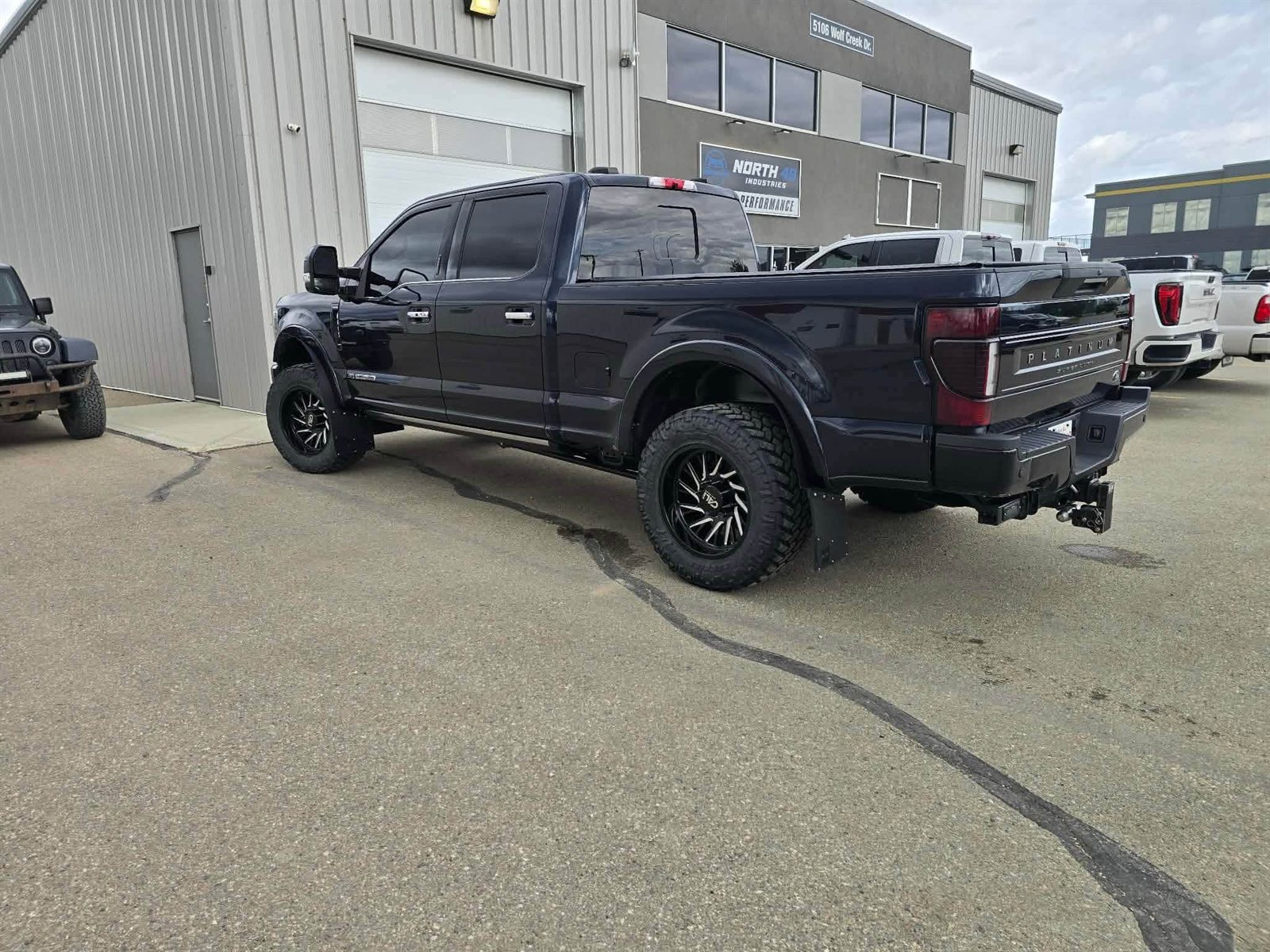 Dark Ford F-350 Platinum Super Duty on black milled wheels